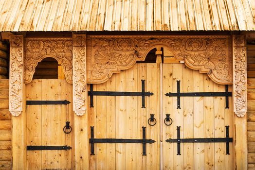 Wooden gate richly decorated with mythology images
