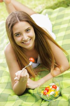 Portrait of happy beautiful young woman eating vegetable salad