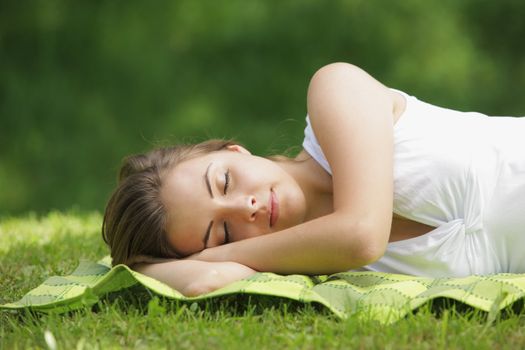 Beautiful woman lying and sleep on the grass