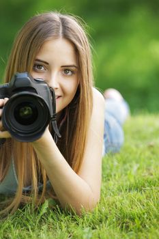 Portrait of beautiful smiling blonde girl , making photos at summer green park.