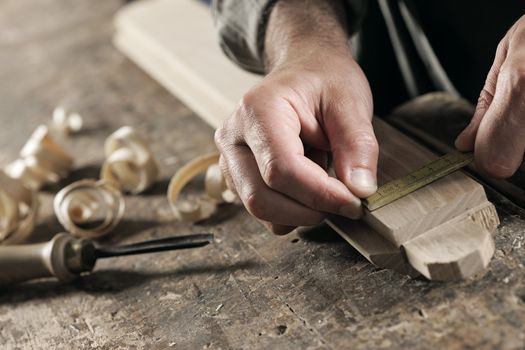 Carpenter Measuring a Wooden Plank