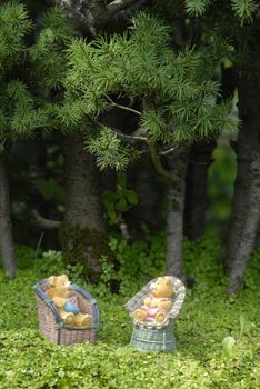 baby teddy bears sitting on the chair in the woods