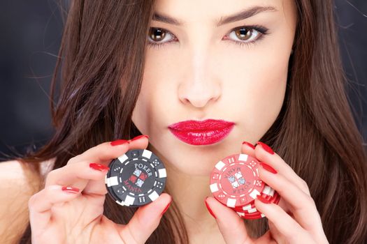 Close up of a pretty woman holding gambling chips