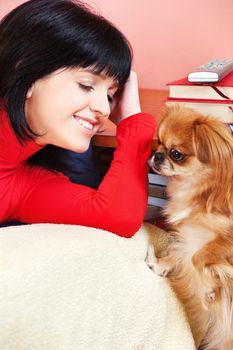 Smiled girl at home with her Pekingese dog