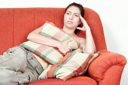Young woman on sofa having headache pain