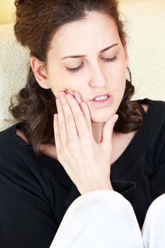 woman having toothache at home