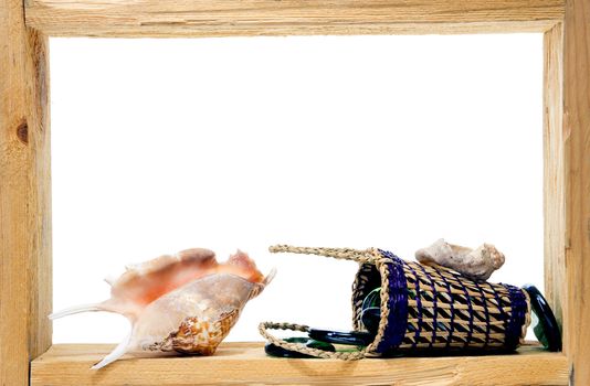 Wicker, green pieces of glass and sea shells inside rough wooden frame on white background