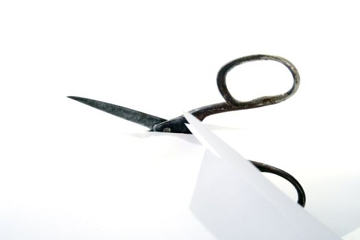 Old rusty steel scissors cut paper on white background