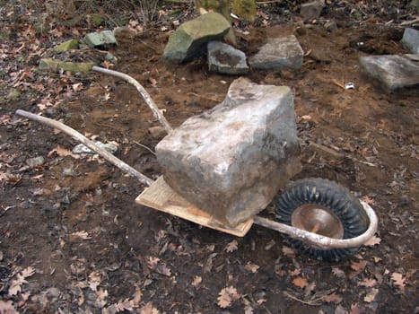 Wheelbarrow fully loaded with heavy stone