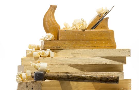 Wooden plane, boards and planed wood shavings on a white background