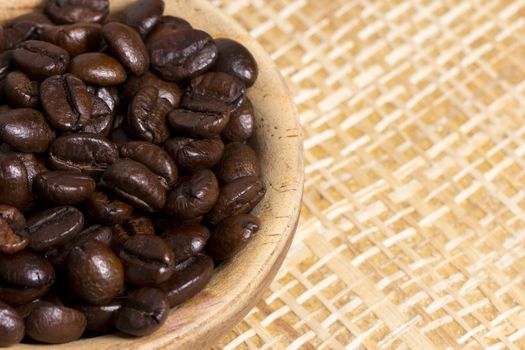 Fresh roasted coffee beans on light textured surface