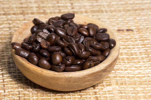 Fresh roasted coffee beans on light textured surface