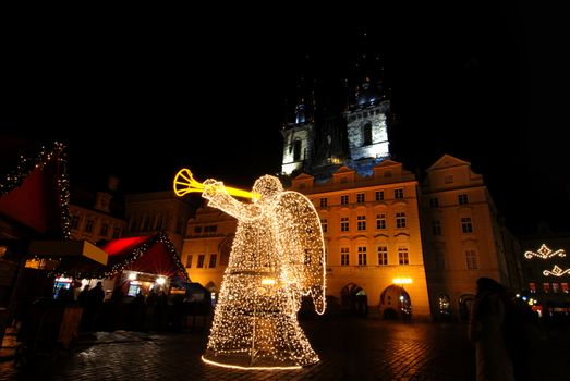 Old Town Square in Prague with Tyn Cathedral and angel during the Christmas celebrations at night