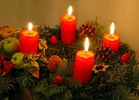 Christmas wreath with four red burning candles