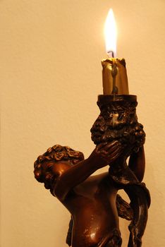 Statue of angel is holding a burning candle - christmas background