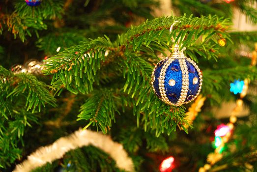Beautiful blue decoration is hanging on a christmas tree. Shallow DOF