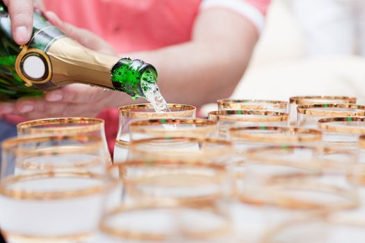 champagne is poured into glasses at the wedding.