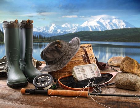 Fly fishing equipment on deck with beautiful view of a lake and mountains