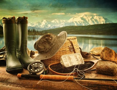 Fly fishing equipment on deck with beautiful view of a lake and mountains