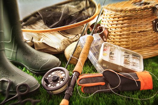 Boots and fly fishing equipment on grass