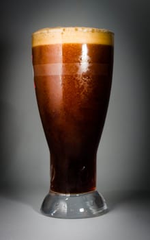 Beer glass full of cold dark beer. Isolated