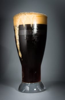 Beer glass full of cold dark beer. Isolated