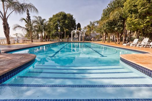 a wide angle view of a clear blue swimming pool in a beautiful setting