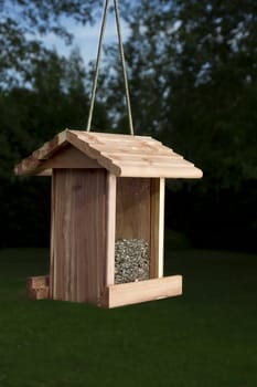 wood bird feeder against a wooden area background