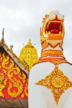 Big lion in front of golden pagoda is the protector