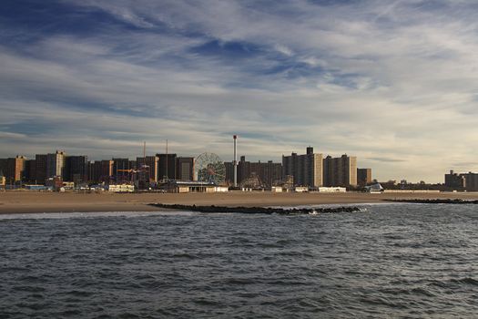 Coney Island beach at sunrise with building in the background and ocean in the foreground
