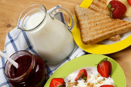 Village Breakfast of Toasts, Strawberries, Jam, Milk and Curds close up on wooden background