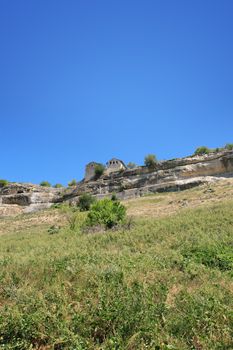 Ancient stone stronghold on the mountain against blue sky