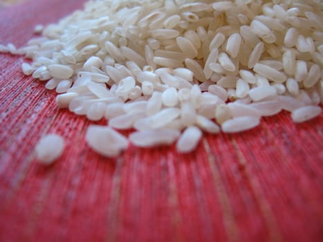 Handful of rice scattered on a red background