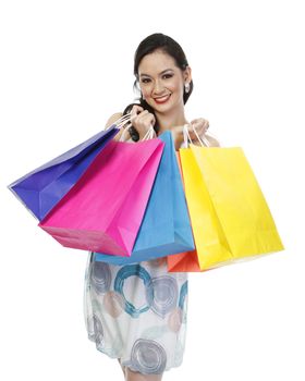 An attractive fashionable woman holding colorful paper shopping bags (isolated on white)