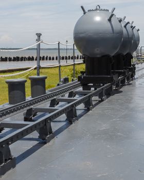 Naval mines were set on the rail at the deck of battleship. This photo is taken at Battleship Memorial, Samuthprakarn, Thailand.