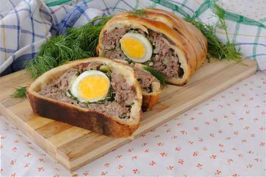 Sliced ​​meatloaf with egg and herbs baked in pastry