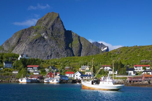 Picturesque town of Reine with fishing boats in the fjord on Lofoten islands in Norway