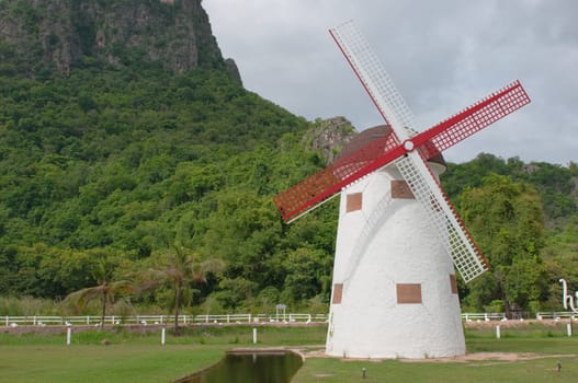 red vintage wind mill in the park 