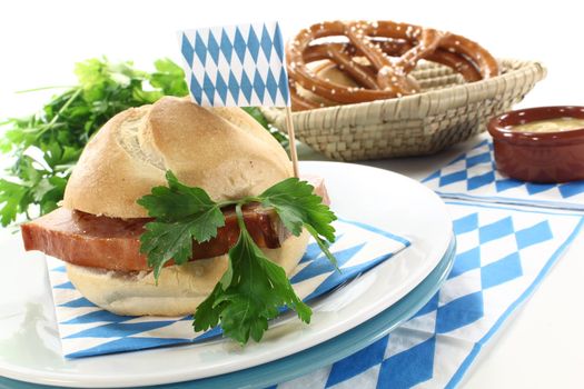 Roll with grilled beef and pork loaf, parsley, Bavarian flag, napkin on a bright background