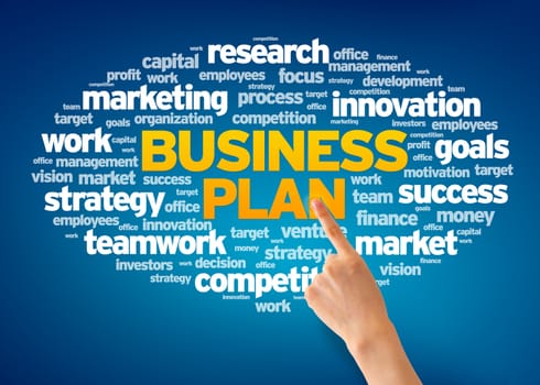 Hand pointing at a Business Plan Word Cloud on blue background.