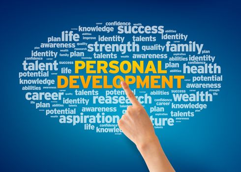 Hand pointing at a Personal Development Word Cloud on blue background.