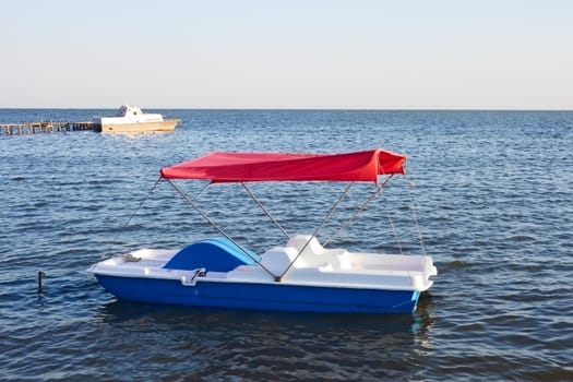 Walking pedal catamaran on the water in a fine summer day