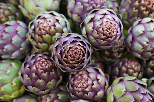 Pile of green and purple Italian Artichokes at the farmers market