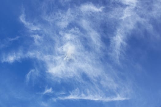 Abstract image of oblong white clouds in blue sky