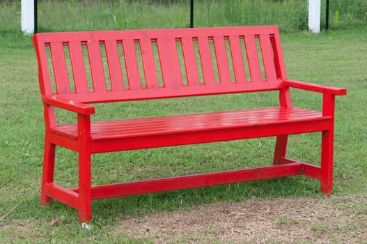 Lonely red wooden bench in the park 