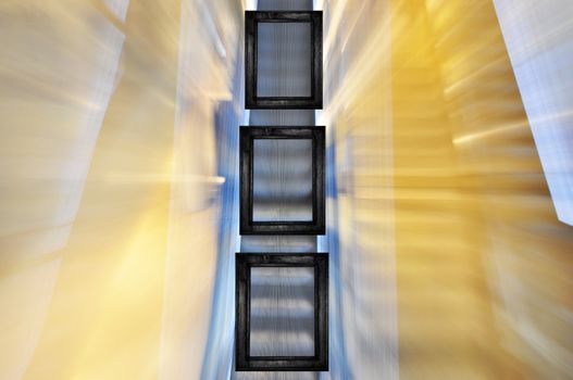 Three black frames in different sizes on blured escalator background.