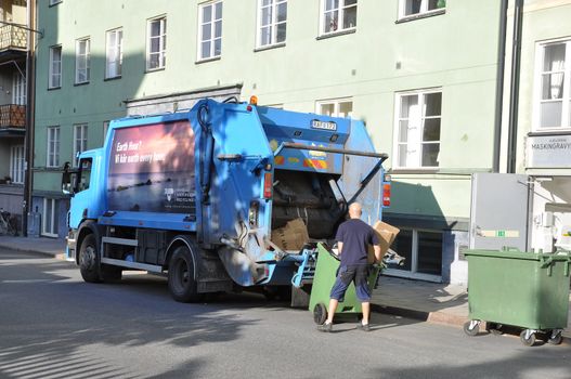 Garbage truck with garbage man early morning in Stockholm, Sweden.