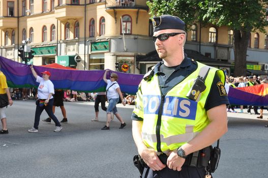 STOCKHOLM, SWEDEN - AUGUST 4: An unidentified policeman protects people taking part in Pride Parade 2012 to support gay rights on August 4, 2012 in Stockholm Sweden.