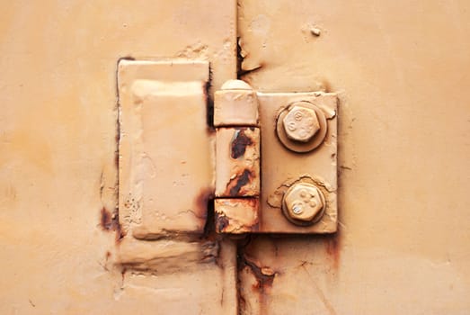 Old rusty metal hinge On The Yellow Door