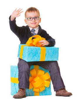 Small boy in spectacles with big present on white background
